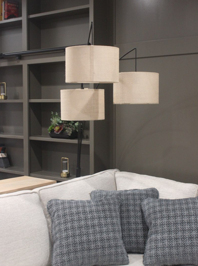 Couch with lamps behind it with a textured wall.